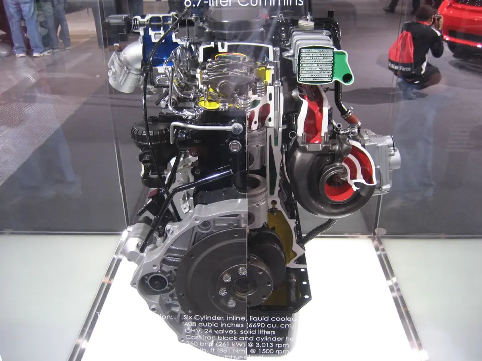 Motor Cummins de 6.7 litros seccionado (cortado para mostrar su interior) en una exhibición, detrás de un cristal — aquí no se ve la tapa de válvulas; en el taller, la tapa roja es la pista